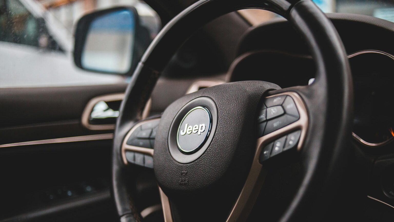 Detailed view of a Jeep steering wheel, showcasing luxury automotive interior design.